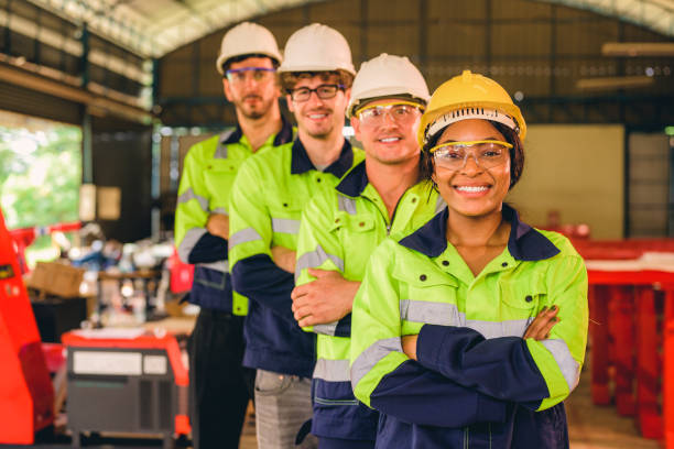 Group of confident engineers workers smiling standing at manufacturing factory